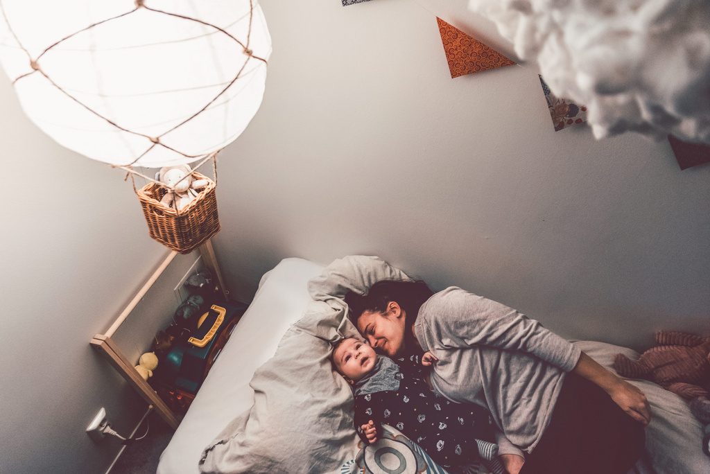 happy mom sleeping alongside baby 