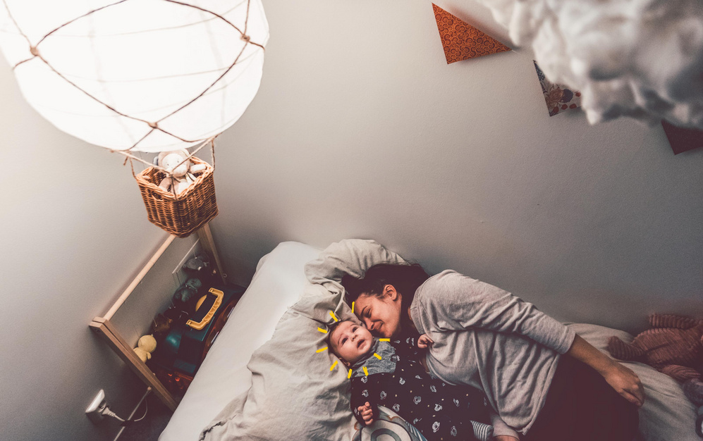 happy mother sleeping alongside baby with sunshine