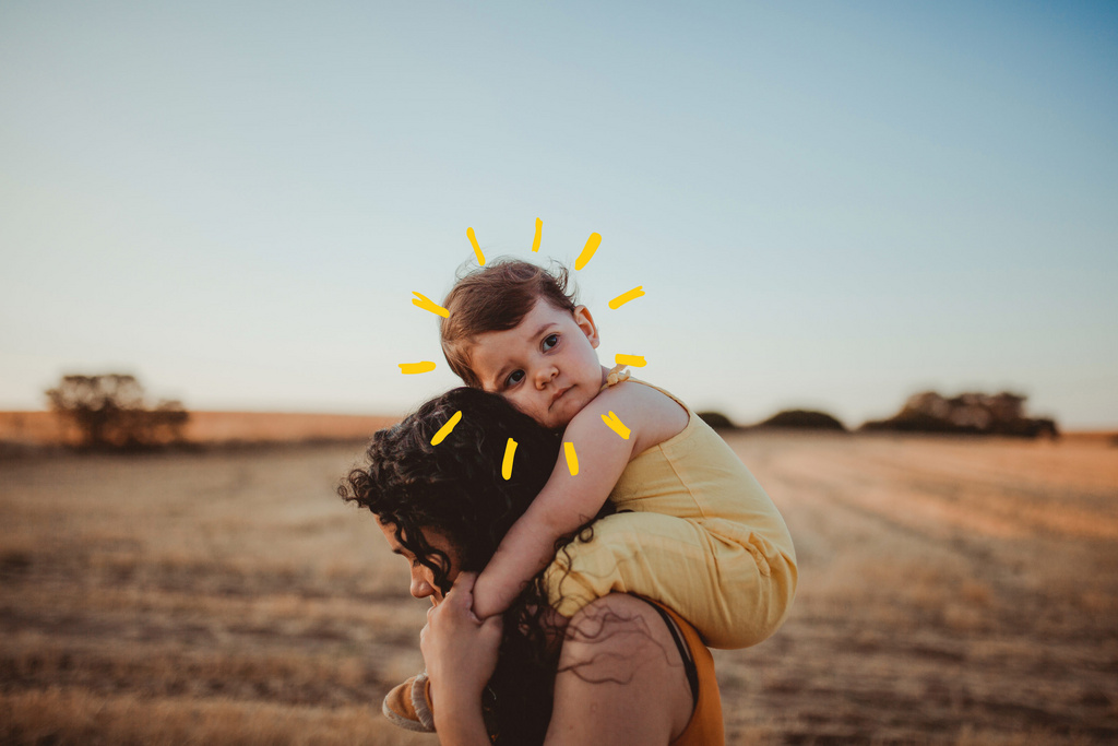 sad baby on mothers shoulders with sunshine 