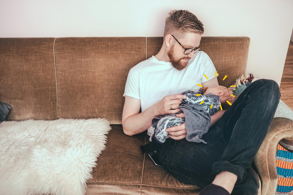 dad holding sleepy baby with sunshine