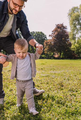 dad helping baby to walk 