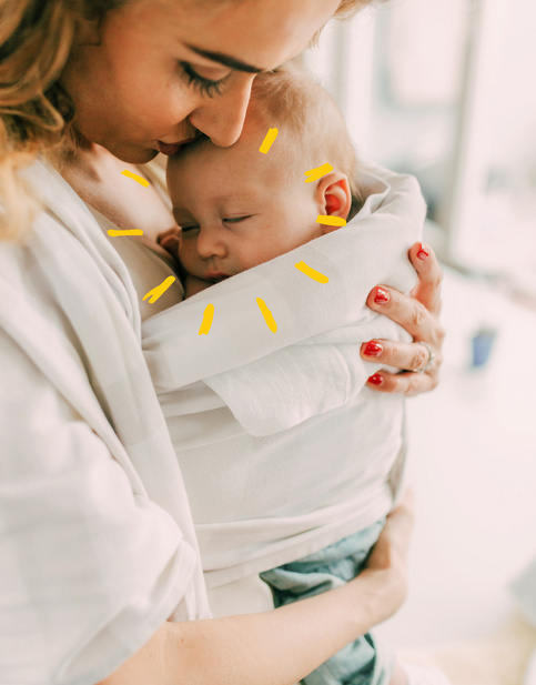 mom holding her baby close with sunshine